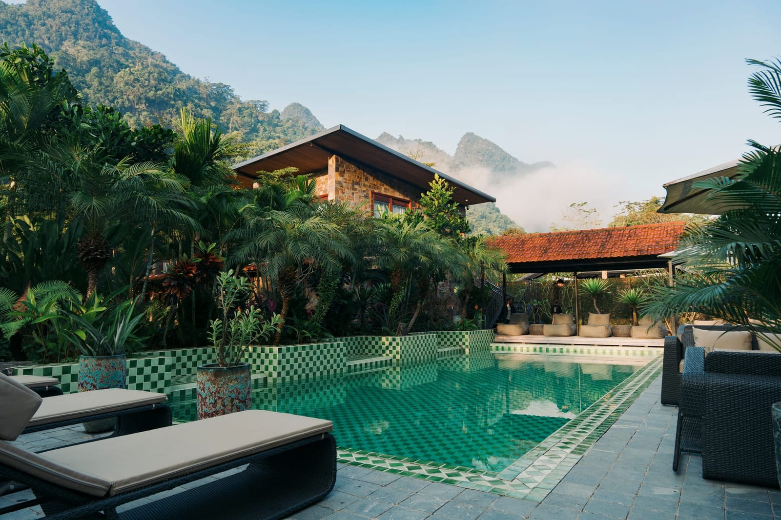 The Flipside Villa pool at first light, the stone house and the mountains behind it