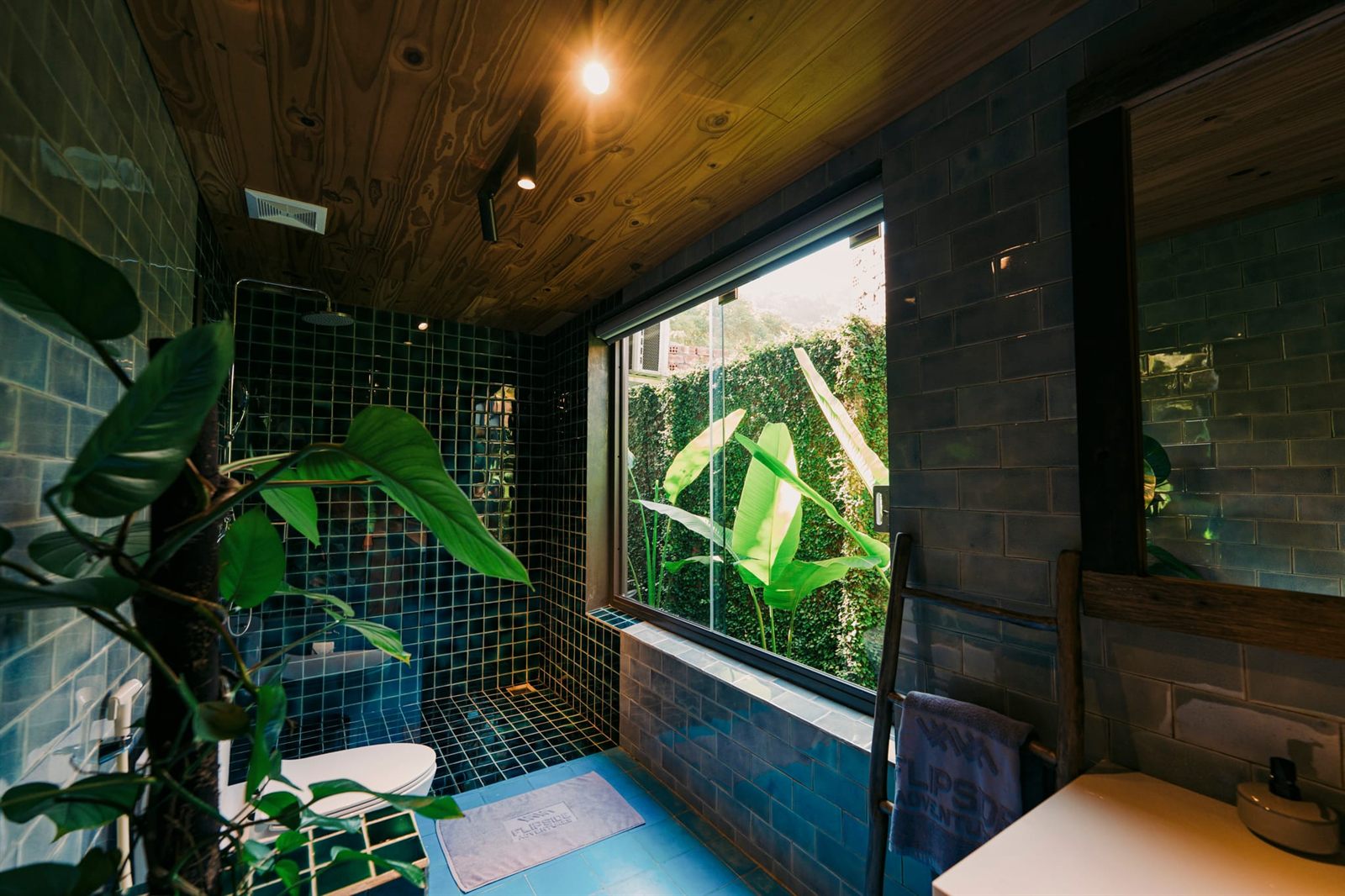 Bathroom with green tiles and plants