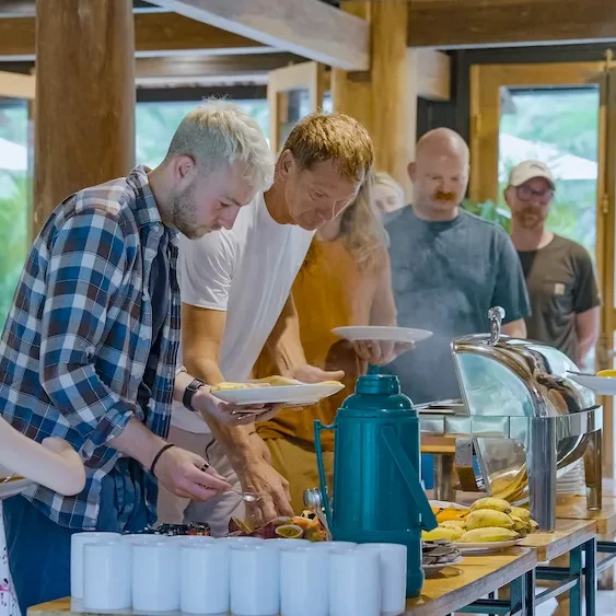 Riders helping themselves at the breakfast buffet under the timber roof