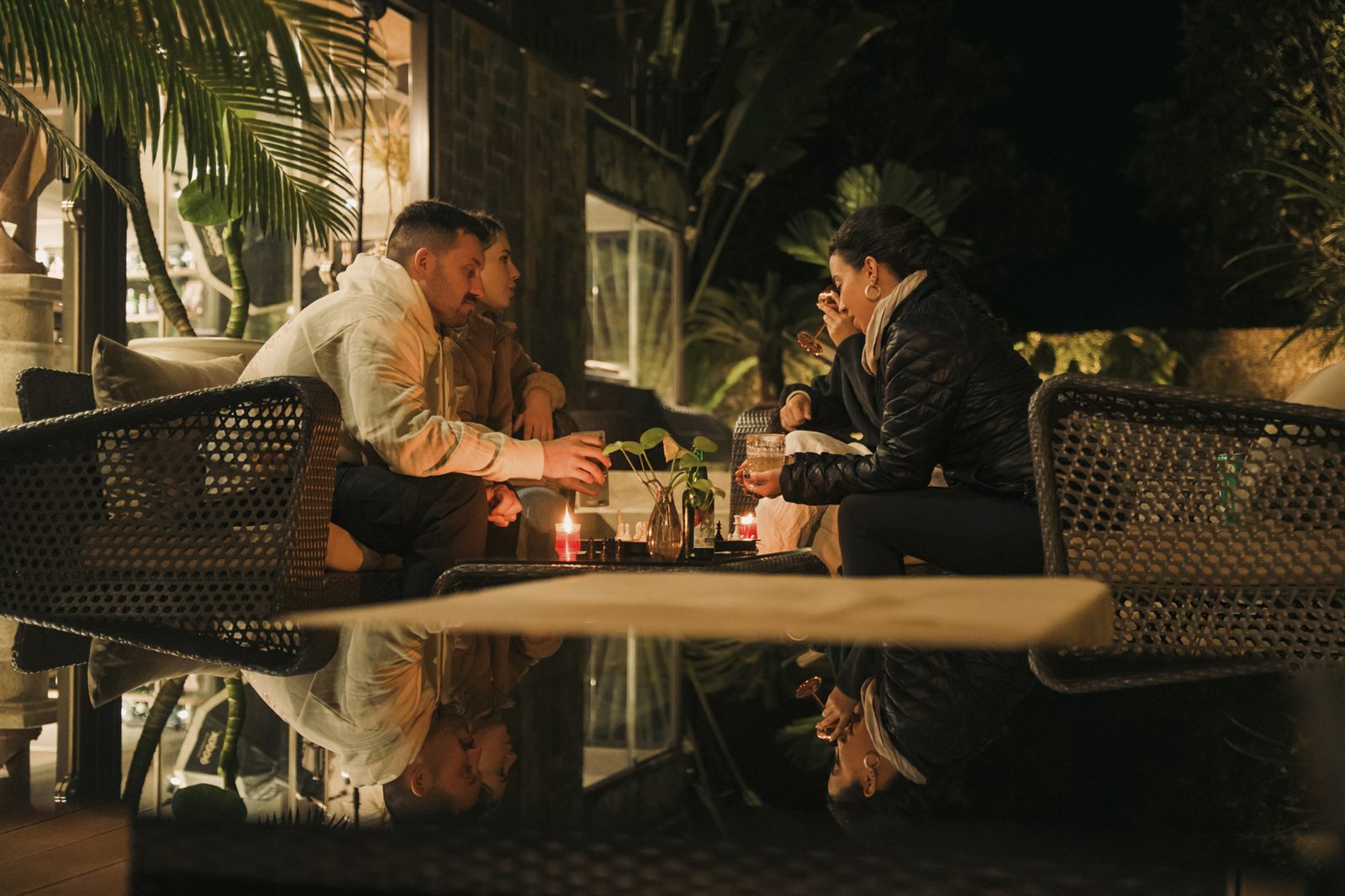 People eating outside by candlelight