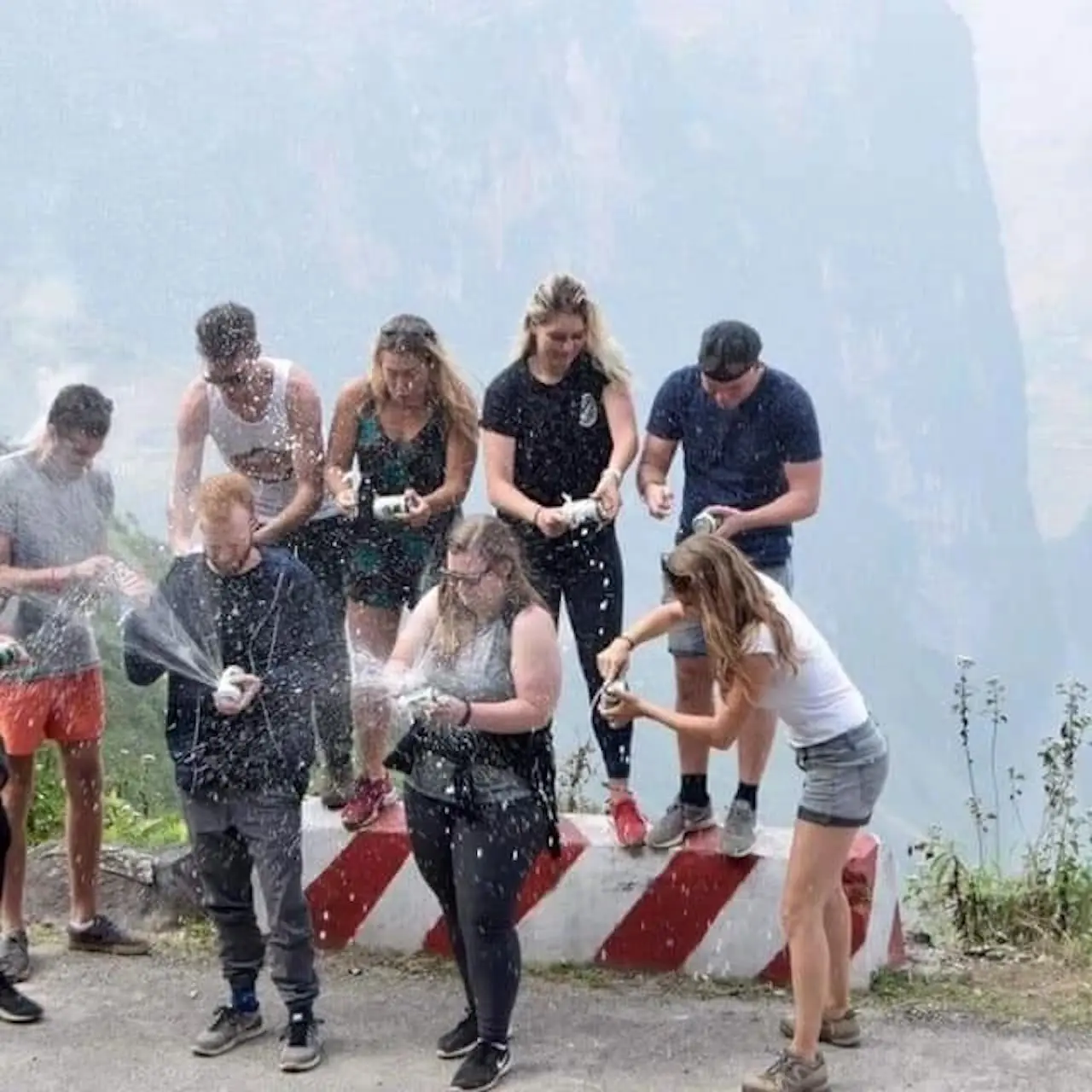 The group spraying drinks over each other at the end of a day on the road