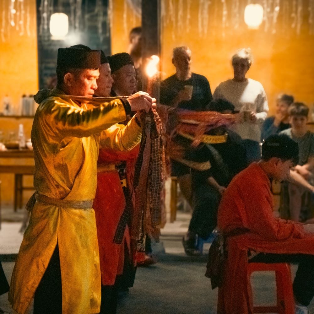 A local ceremony by lamplight, the celebrant in a yellow robe