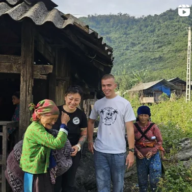 Travellers greeted by two women outside a homestay